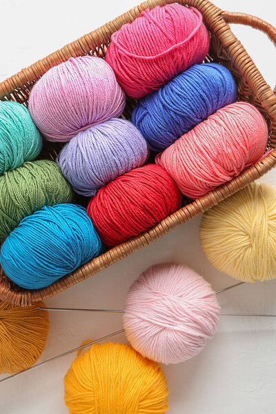 Корзина с шариками вязальной пряжи на светлом фоне
