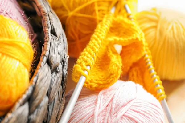 Knitting yarn with needles and unfinished clothes, closeup