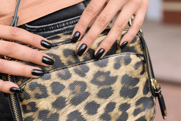 Fashionable young woman with black manicure outdoors, closeup