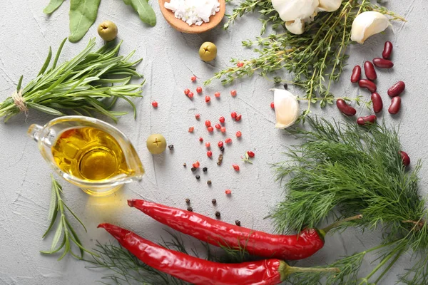 Fresh herbs with spices and oil on grey textured background