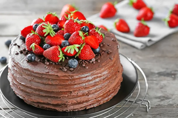 在木桌上装饰草莓和蓝莓的美味巧克力蛋糕 — 图库照片