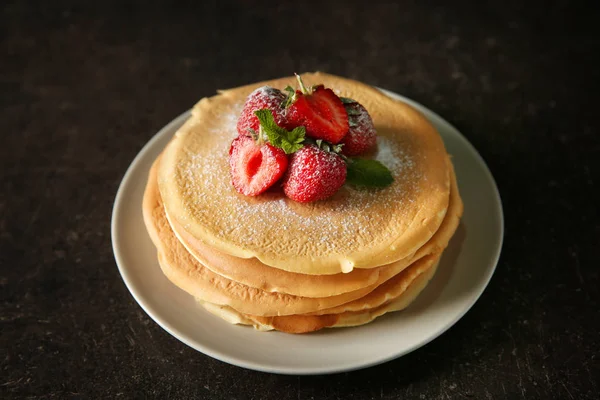 Teller Mit Leckeren Pfannkuchen Und Erdbeeren Auf Dunklem Tisch — Stockfoto