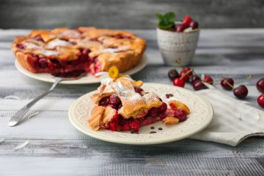 Ahşap masa üzerinde lezzetli vişneli turta ile plaka