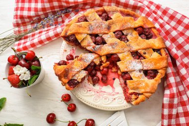 Beyaz ahşap masa üzerinde taze çilek ile lezzetli ev yapımı vişneli tart