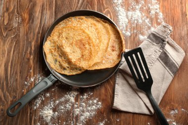 Ahşap masa üzerinde lezzetli ince krep tava