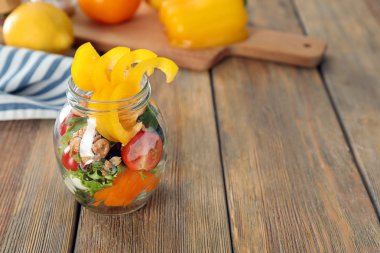 Ahşap masa üzerinde kavanoza lezzetli sebze salatası