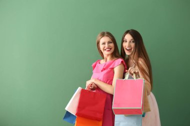Güzel genç kadınlarla renk arka plan üzerinde alışveriş torbaları