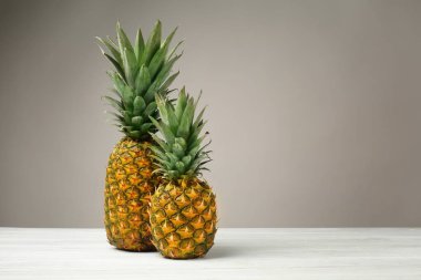 Ahşap masa gri arka plan üzerinde lezzetli ananas