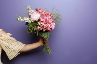 Renkli arka planda güzel çiçekleri olan genç bir kadın.