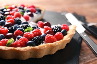 Lezzetli berry pie ahşap tablo, closeup ile kayrak plaka