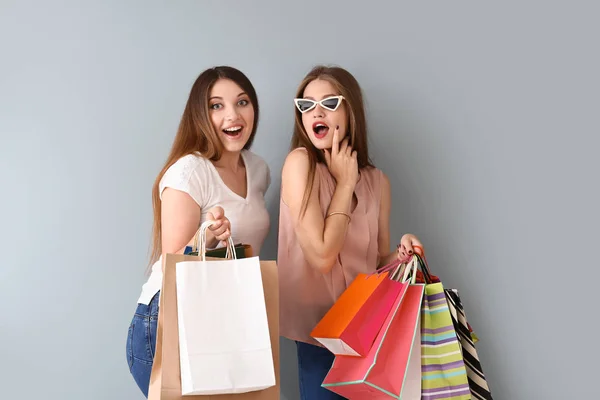 Schöne Junge Frauen Mit Einkaufstaschen Auf Hellem Hintergrund — Stockfoto