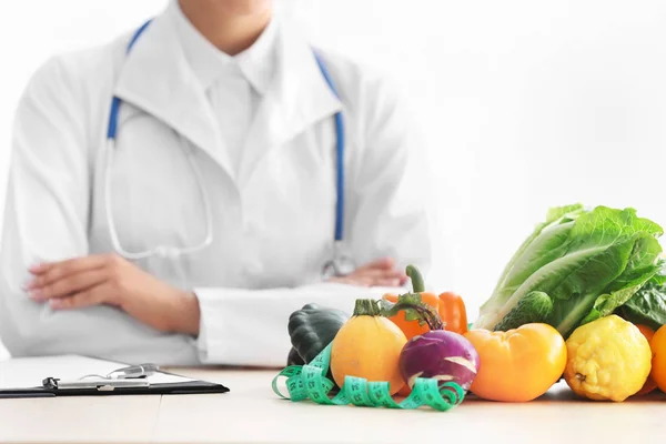 Nutricionista Femenina Sentada Mesa Con Portapapeles Productos Saludables Sobre Fondo — Foto de Stock