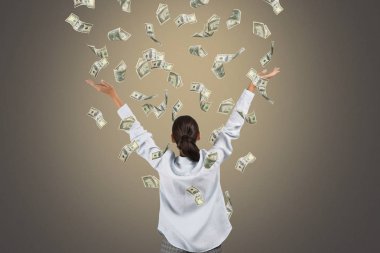 Gri arka plan üzerinde doları banknot ile mutlu zengin kadın