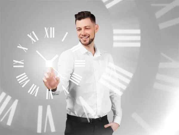灰色の背景に仮想時計を持つビジネスマン 時間管理の考え方 — ストック写真