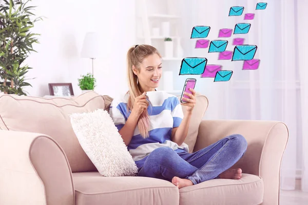 Happy woman using cellphone to check an email at home