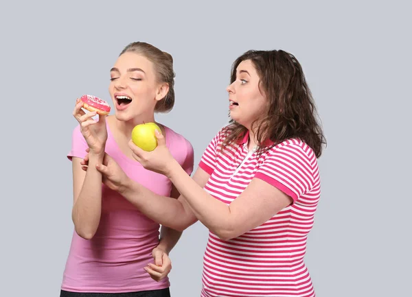 Młoda Kobieta Stout Oferując Jej Apple Slim Przyjaciel Zamiast Cukierka — Zdjęcie stockowe