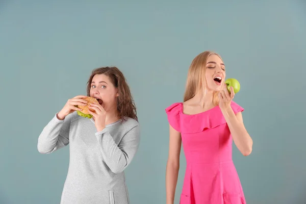 Женщины Едят Сером Фоне Выбор Между Диетой Нездоровой Пищей — стоковое фото