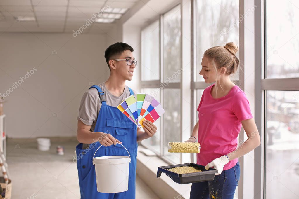 Professional painters choosing the color of wall indoors
