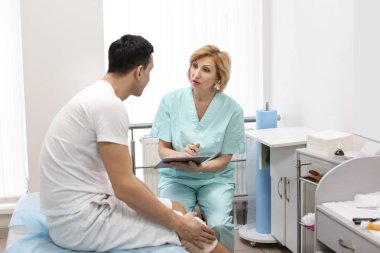 Ortopedi uzmanı ve hasta ile hastane bacağından sargılı