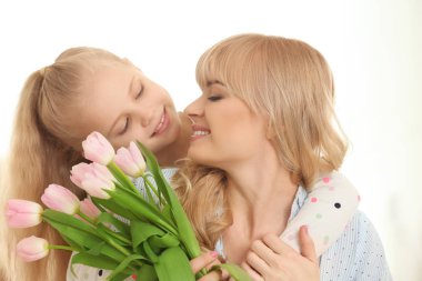 Sevimli küçük kız ve annesi Lale buketi evde ile portre