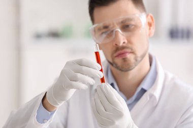 Bilim adamı holding tüp ile renk örneği laboratuvar