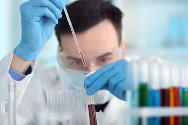 Laboratuvarda kan örneğiyle çalışan bilim adamı.