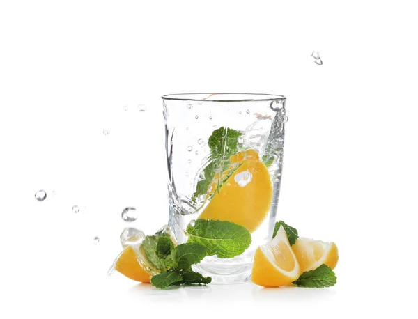 ガラス 水と白い背景の上のスライスの柑橘系の果物をはねて — ストック写真