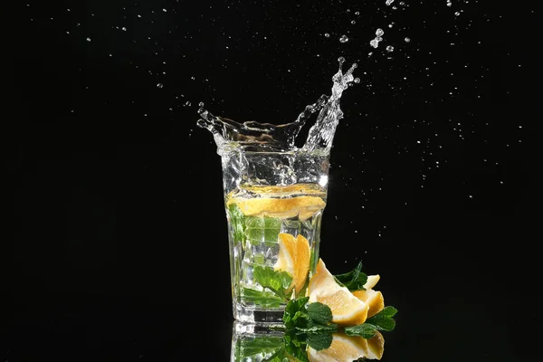 Bicchiere Con Spruzzi Acqua Fette Limone Fondo Nero — Foto Stock