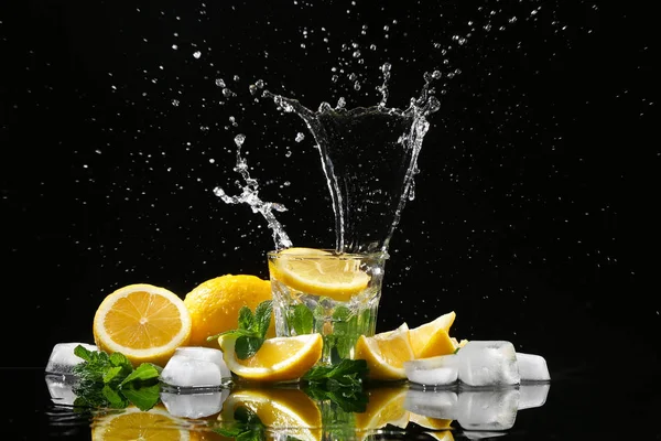 Bicchiere Con Spruzzi Acqua Fette Limone Fondo Nero — Foto Stock