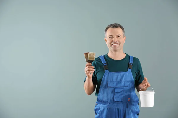 Pintor Masculino Uniforme Con Pinceles Cubo Pintura Sobre Fondo Color —  Fotos de Stock