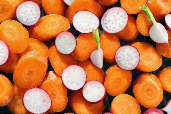 Ripe sliced radish and carrot as background, closeup