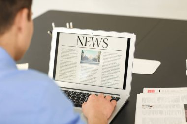 Genç işadamı dizüstü bilgisayar ekranında Office haber okuma