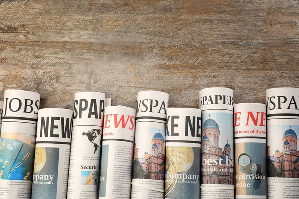Rolled Newspapers Wooden Background — Stock Photo, Image