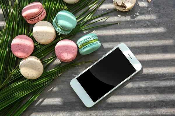 Flache Liegekomposition Mit Leckeren Macarons Smartphone Und Palmblättern Auf Grauem — Stockfoto