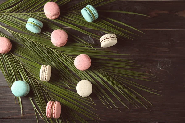 Flat Lay Composition Tasty Macarons Palm Leaves Dark Background — Stock Photo, Image