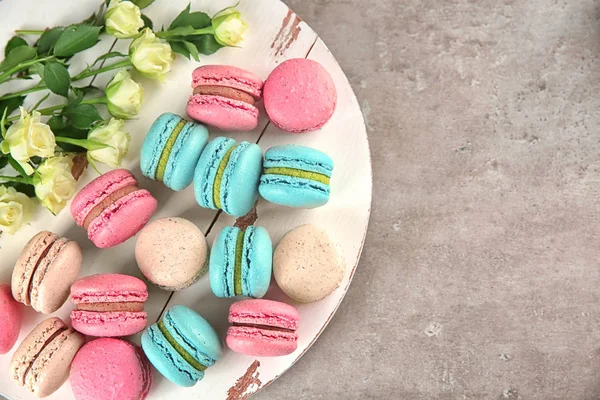 Board Tasty Macarons Roses Grey Background Top View — Stock Photo, Image