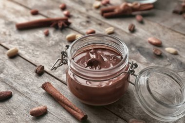 Ahşap masa üzerinde erimiş çikolata ile jar