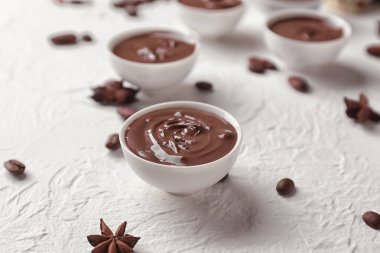 Işık arka plan üzerinde erimiş çikolata ile kase