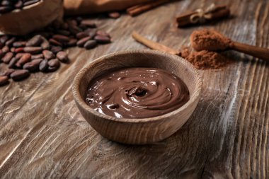 Ahşap masa üzerinde erimiş çikolata ile kase
