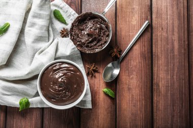 Kase ve kepçe ile ahşap masa üzerinde erimiş çikolata