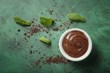 Renk arka plan üzerinde erimiş çikolata ile kase