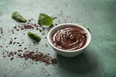 Renk arka plan üzerinde erimiş çikolata ile kase