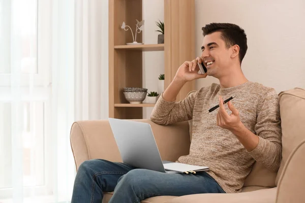 Young Freelancer Talking Phone While Using Laptop Home — Stock Photo, Image