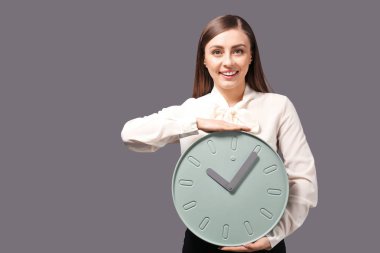 Gri arka plan üzerinde saat olan kadın. Zaman yönetimi kavramı