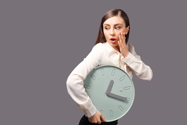 在灰色背景时钟的困扰妇女 时间管理概念 — 图库照片