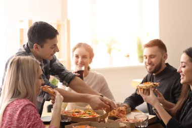 Gençler masada kapalı pizza yemek