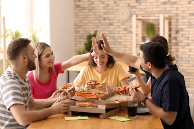 Gençler masada kapalı pizza yemek