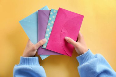 Zarfların renk arka plan üzerinde tutan kadın