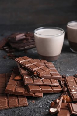 Sütlü çikolata parçaları ile badem koyu arka plan üzerinde