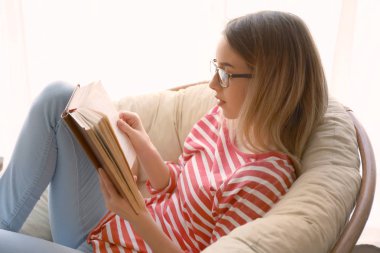 Genç kadın evde ilginç bir kitap okuma